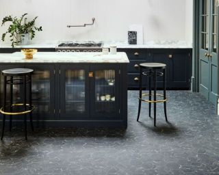 Luxe dark kitchen island with marble worktop and dark grey vinyl flooring